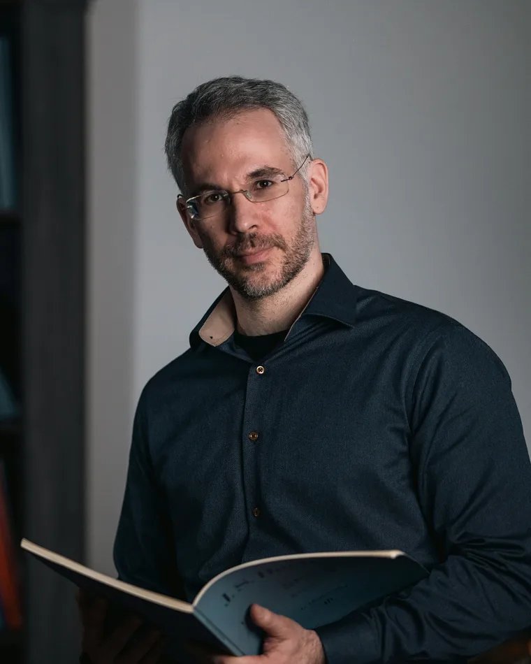 Portrait of Dimitris Petrovas holding a score in his studio